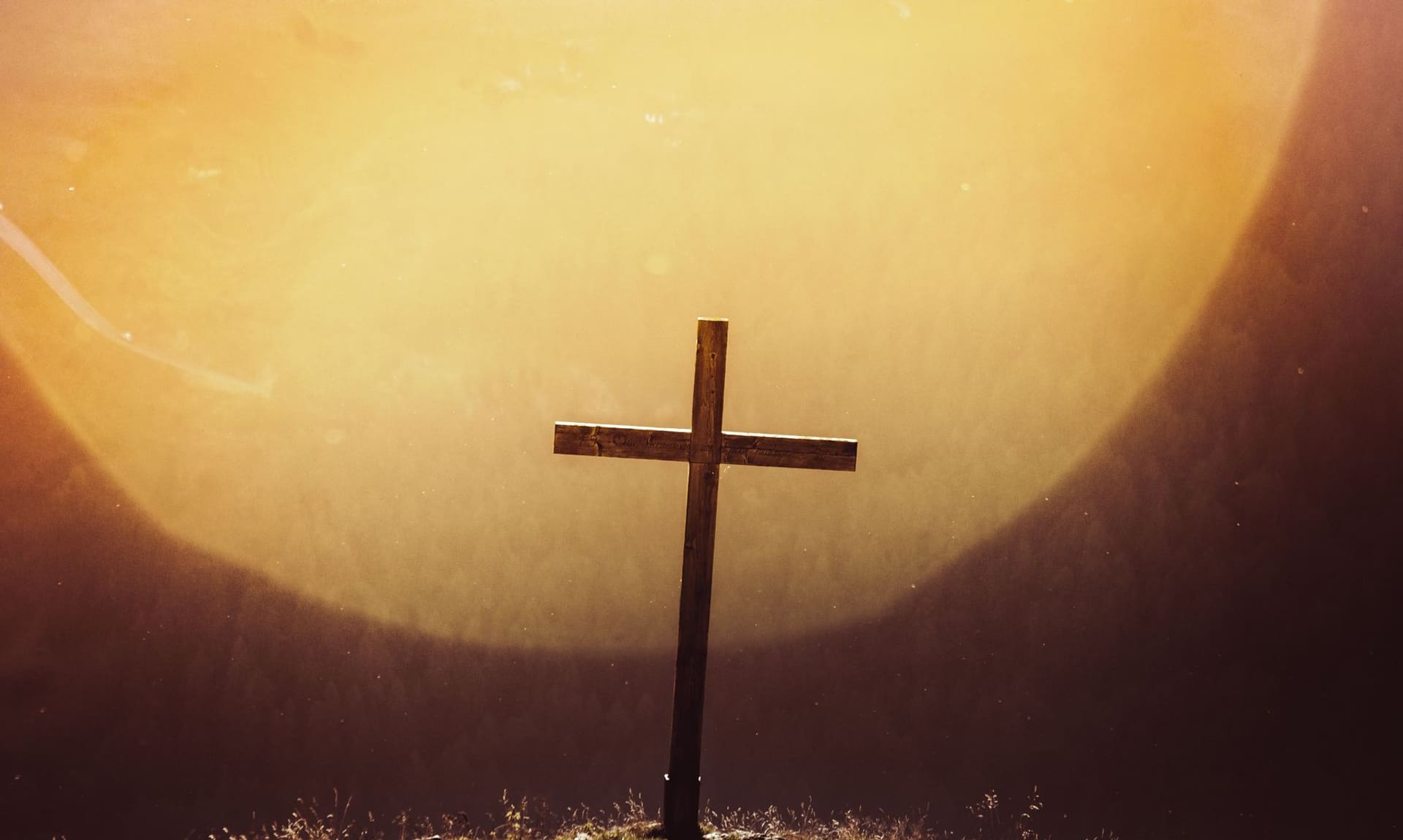 A simple wooden cross bathed in warm morning light