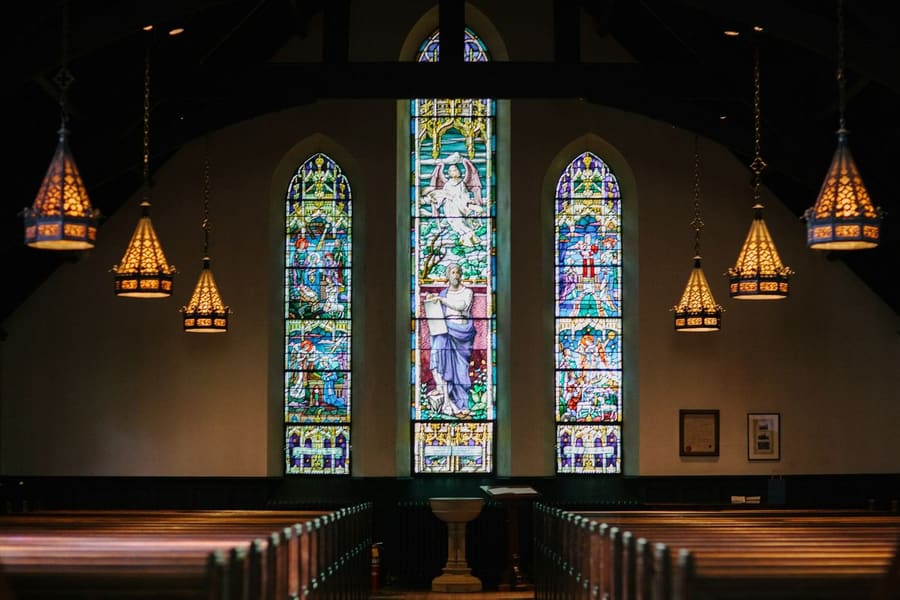Quiet sanctuary pews lit by stained glass windows